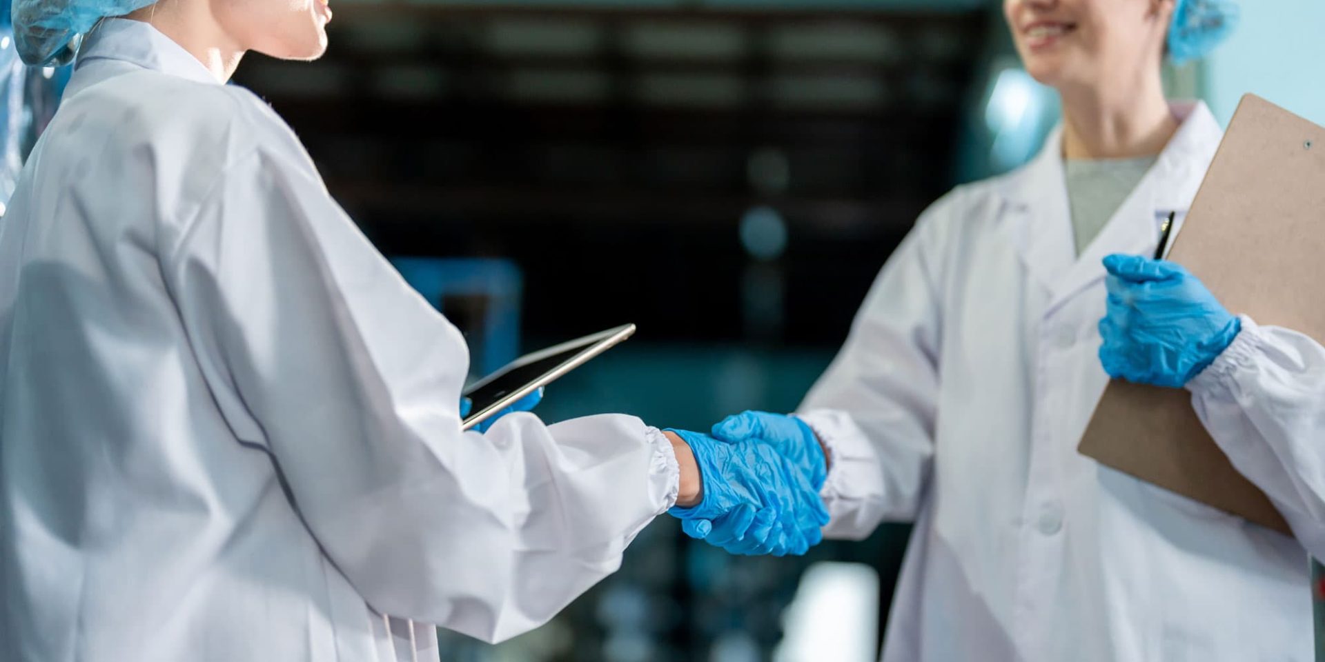 Two food factory workers shake hands after completing food factory training