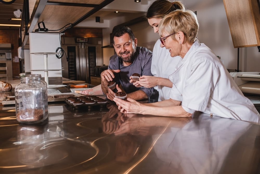 Future of food and beverage industry UK: Food production team reviewing baked goods together in a commercial kitchen environment