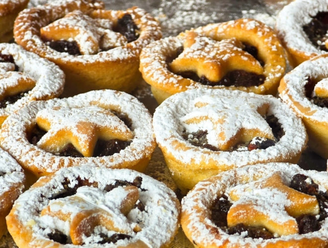 Mince pies dusted with icing sugar sit in neat rows, reflecting seasonal food manufacturing in the UK.